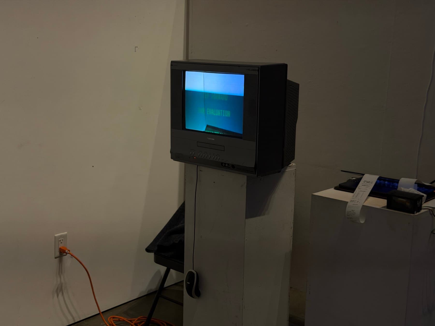 The installation: a CRT on a plinth running the evaluation, with the thermal printer on a second plinth